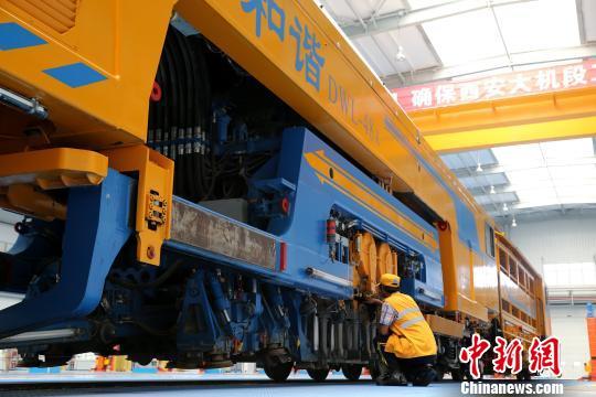 图为工人正在清理大型养路机械。　张远 摄